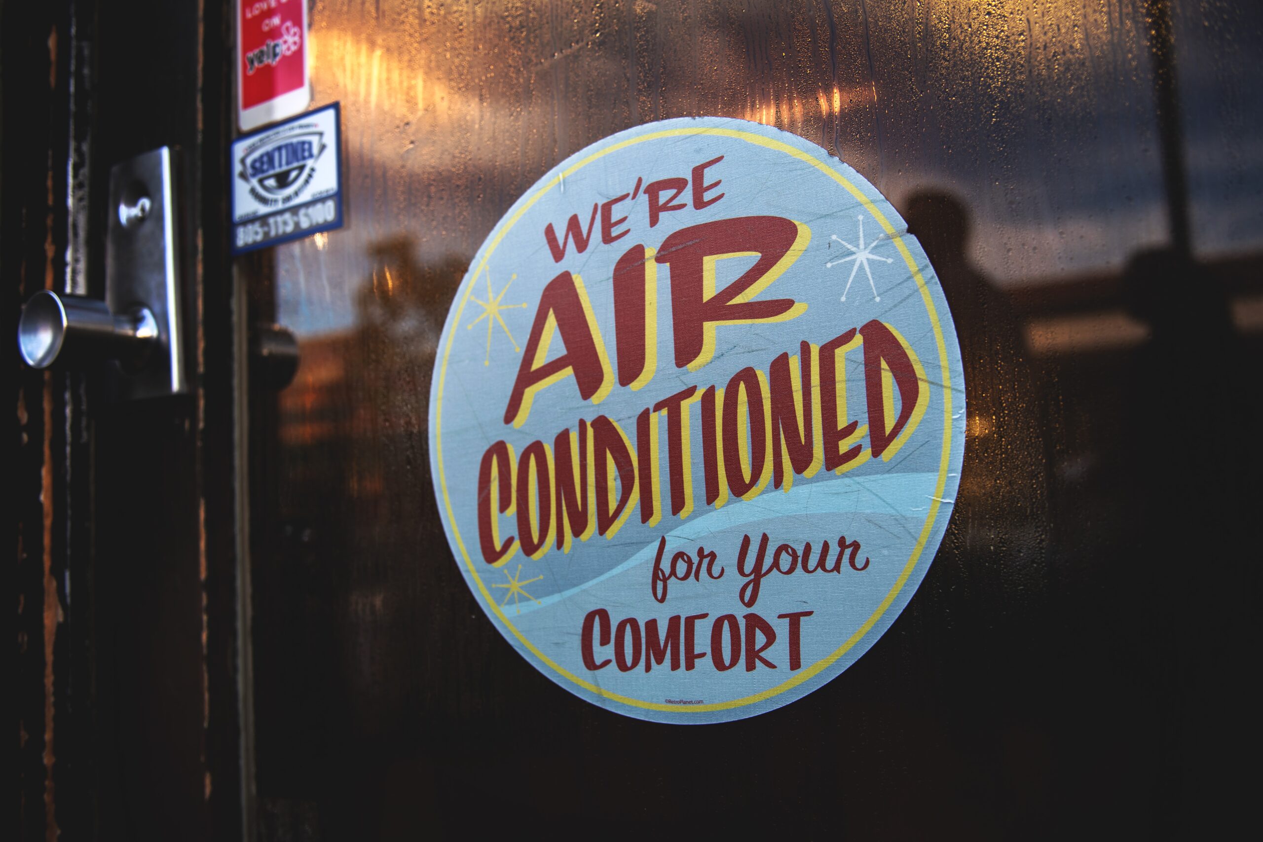 Sign at a business that reads We're Air Conditioned For Your Comfort.