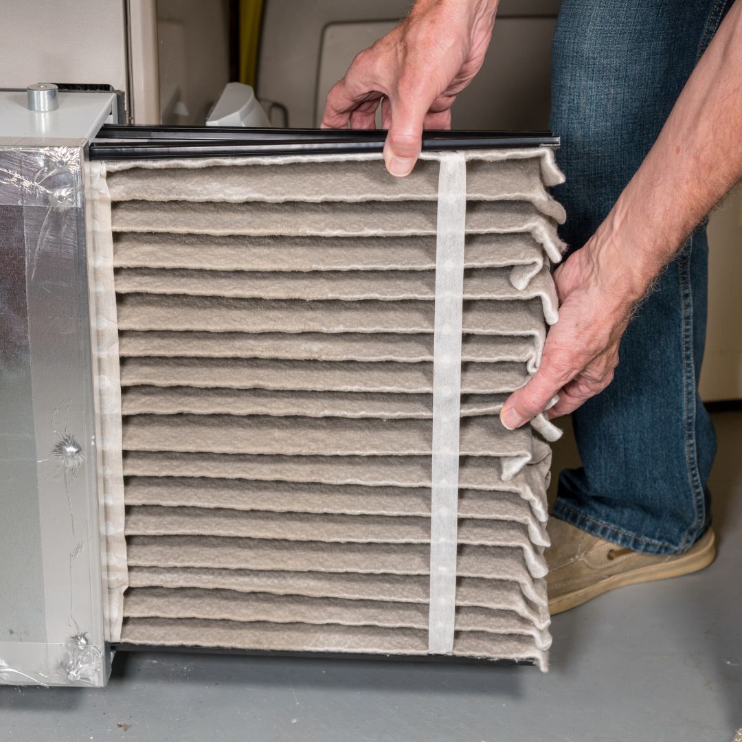 person replacing an air filter